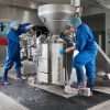 Two people cleaning a food processing area stood on Morland Service Antibacterial rubber industrial doormat