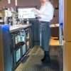 Bar server behind a bar standing on a single piece of Morland Service Anti bacterial rubber industrial doormat