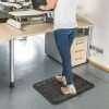 Woman at a standing desk on a Morland Comfort office anti-fatigue mat