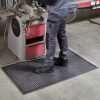 Man at an industrial workstation standing on a Morland Active Industrial Rubber Anti-fatigue Mat
