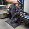 Person standing at an industrial workstation on a Morland Comfort Structure Industrial Rubber Anti-fatigue mat